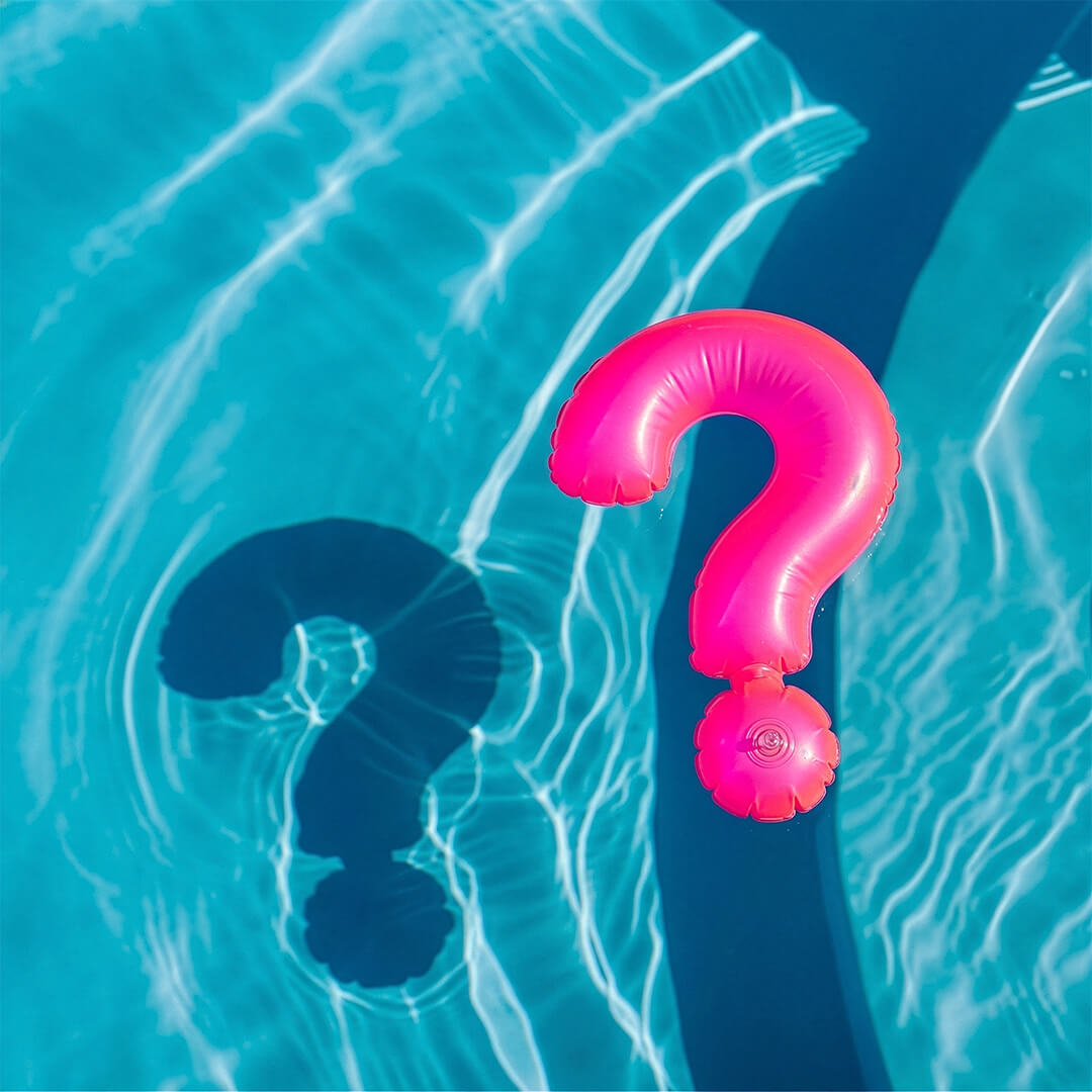 Pink question mark inflatable pool toy in clear blue water
